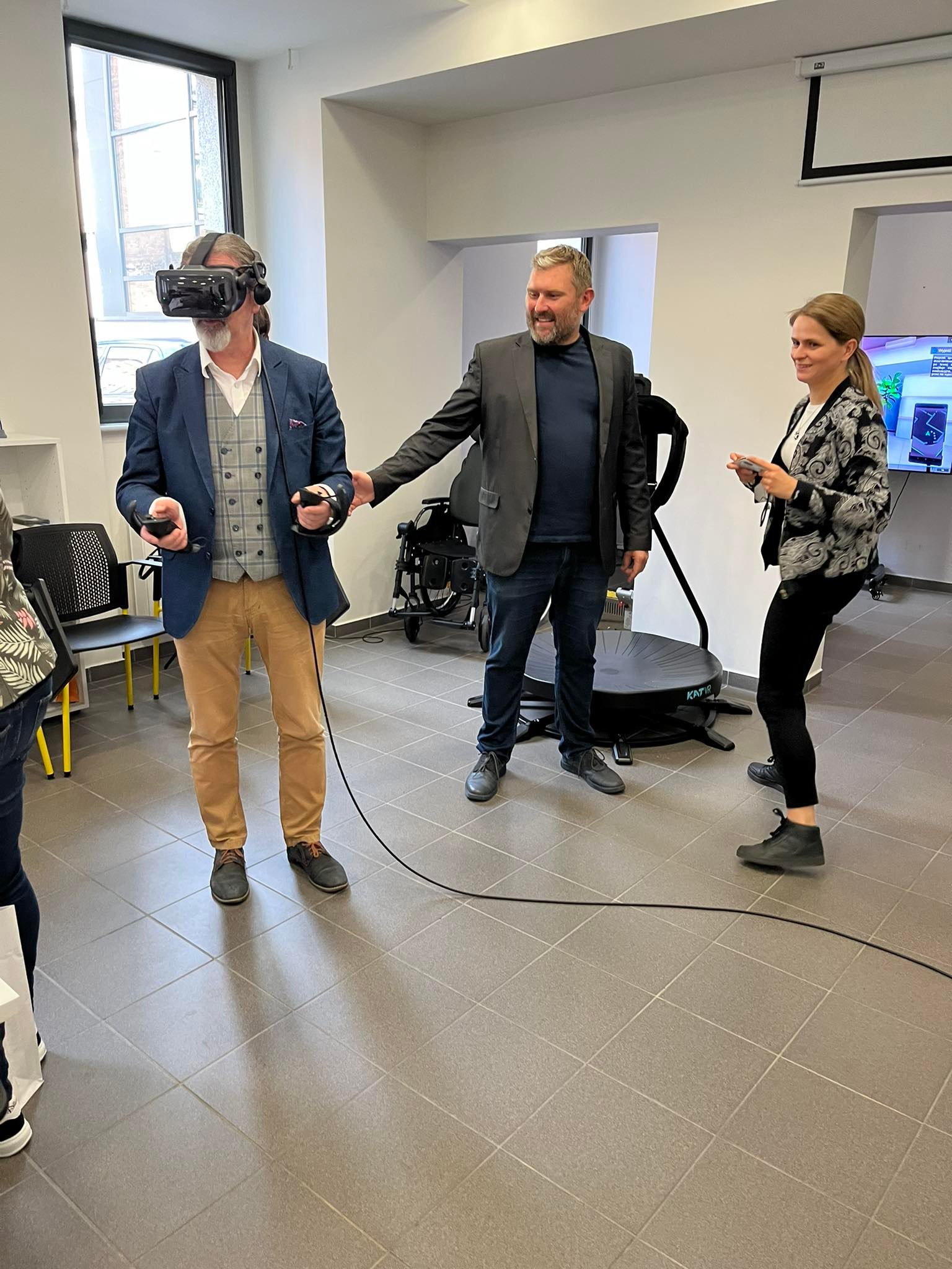 Adam Zwoliński z osobami testującymi hełm VR